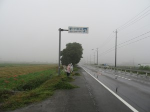 写真：雨のためカッパを着て国道306号の草刈りをする様子