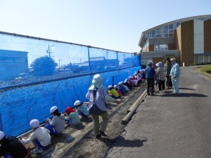 写真：児童とその保護者、地域の皆さんが協力して茶畑の暴風ネットを張る様子