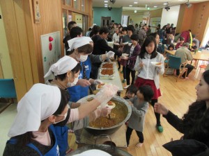 写真：里カレーの食べようとカレーを配る鍋の前に沢山の方が並ばれました