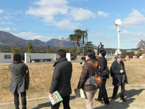 写真：石榑小学校の校舎・グラウンドの見学 右端が柳教授