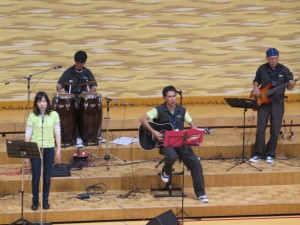 写真:先生や実行委員らによりギター、ドラムなどの楽器を使って「石心バンド」が曲を演奏するお薄