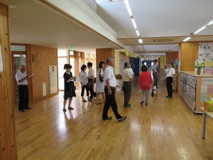 写真：滋賀県の竜王小学校コミュニティスクールの方々が校舎内・授業風景を見学する様子