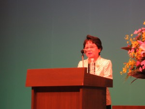 写真:シンポジウムで遠山パナソニック教育財団理事長が壇上で挨拶する様子