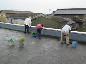 写真：校舎の屋上にたまった土砂をスコップで取り除く様子