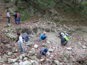 写真：山の途中の蛍石の採掘場跡付近で子どもも大人も蛍石の採取に夢中になっている様子